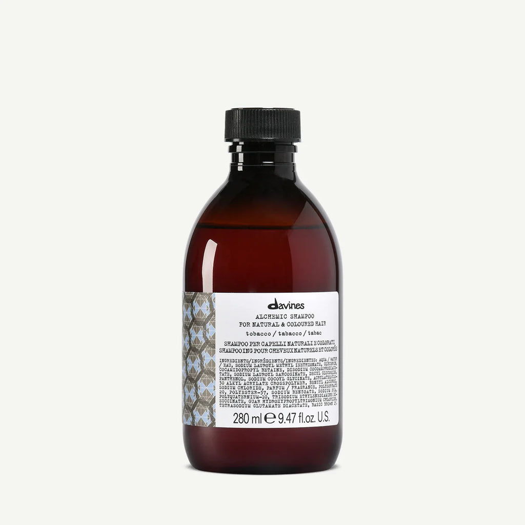 Flaska med Alchemic Shampoo Tobacco schampo i brun förpackning, designad för naturligt och färgat hår, innehållande 280 ml miljövänlig hårvårdsprodukt.