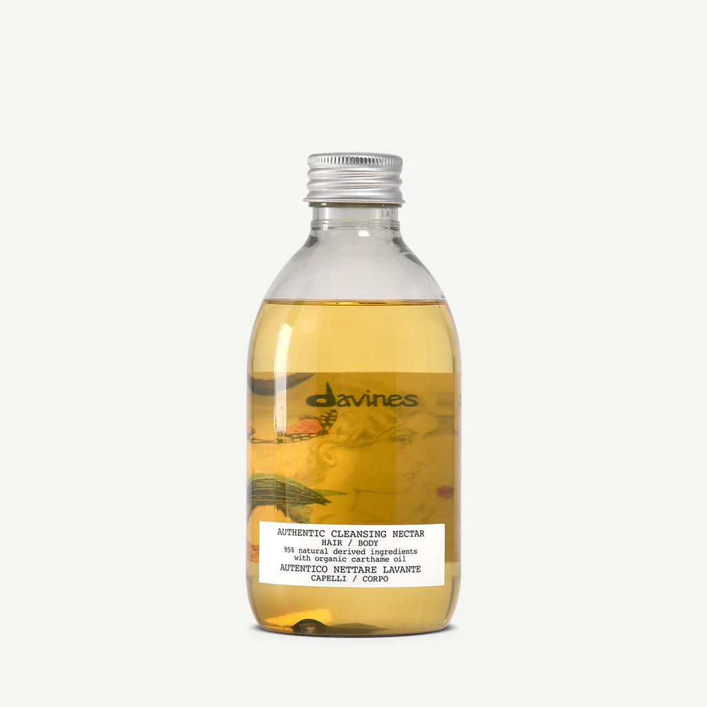Flaska med ljusgul vätska, Authentic Cleansing Nectar, miljövänlig hårvårdsprodukt för rengöring och skonsam vård av hår och kropp.