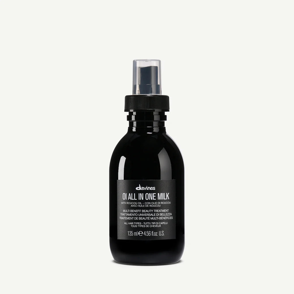 Svart flaska med pump innehållande OI/All In One Milk, en mångsidig styling- och vårdprodukt för håret från Davines.
