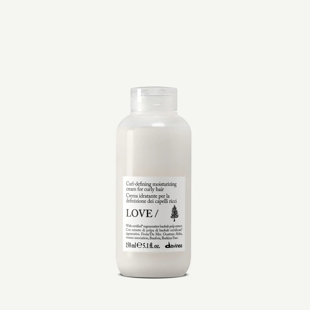Flaska med Love Curl Defining Moisturizing Cream för styling och återfuktning av lockigt hår, en miljövänlig hårvårdsprodukt i enkel vit förpackning.