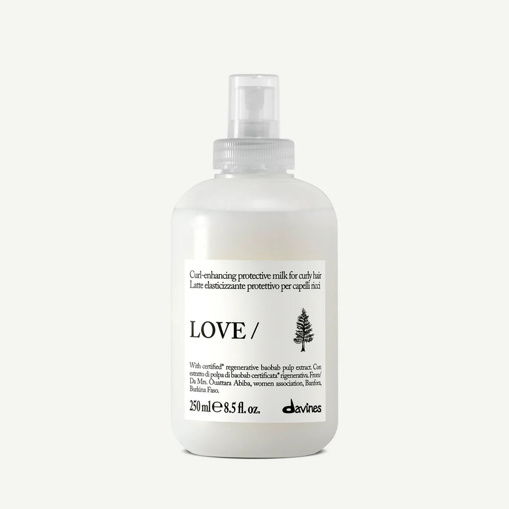 Flaska med Love Curl Enhancing Protective Milk, en vårdande och stylingprodukt för lockigt hår som fungerar som en miljövänlig hårinpackning och balsam.