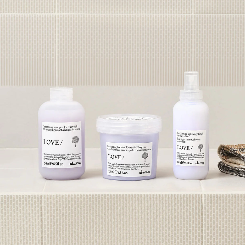 Love Smoothing Shampoo i flaska tillsammans med matchande hårinpackning och lättviktig stylingmjölk från Davines, perfekt för mjukt och slätt hår.