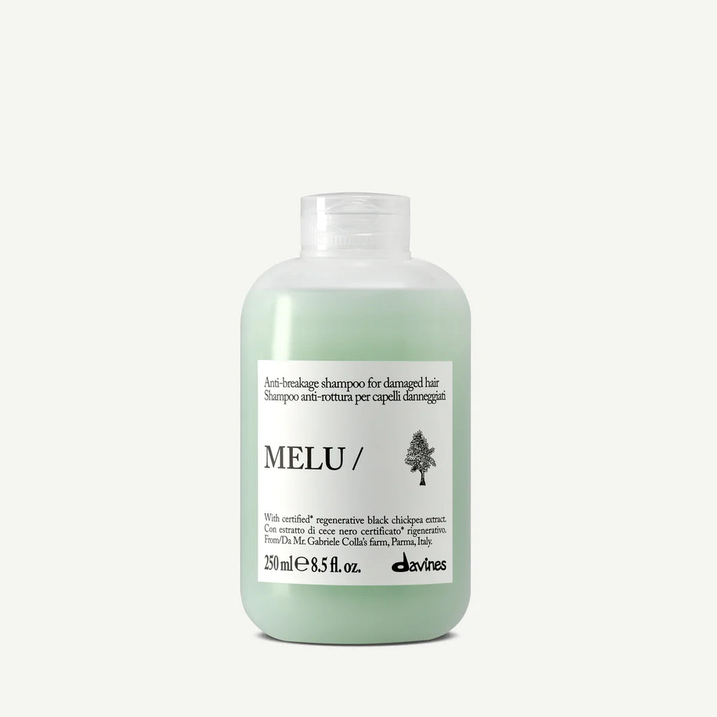 Flaska med Melu Anti-Breakage Shampoo, ett milt schampo för skadat hår i en grönaktig plastflaska med vit etikett och svart text.