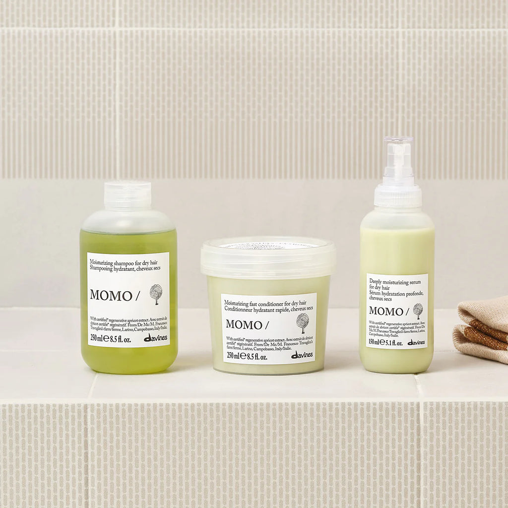 Momo Moisturizing Fast Conditioner tillsammans med andra miljövänliga hårvårdsprodukter i minimalistisk förpackning på beige kakelbakgrund.
