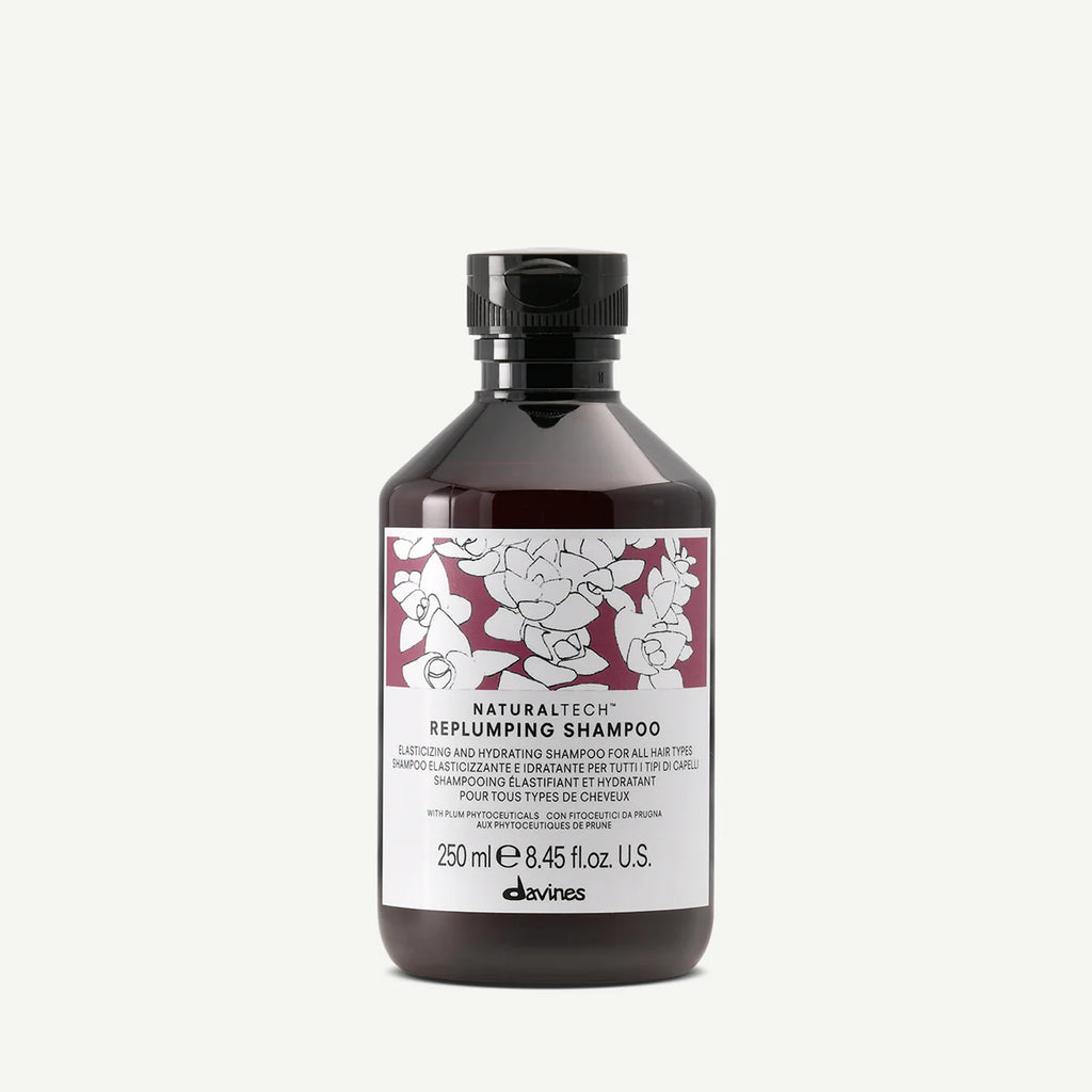 Naturaltech Replumping Shampoo i mörk flaska med etikett i vitt och vinrött, miljövänligt schampo som ger fyllighet och återfuktning till håret.
