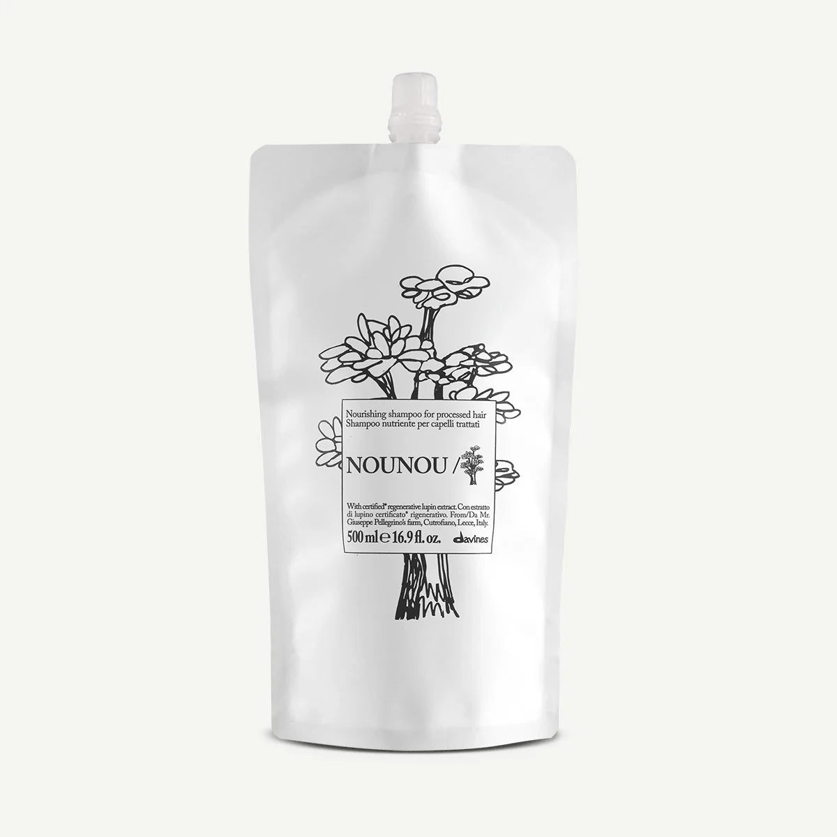 Vit påse med svart illustration av blommor och texten Nounou Nourishing Shampoo, en miljövänlig hårvårdsprodukt för närande schampo.