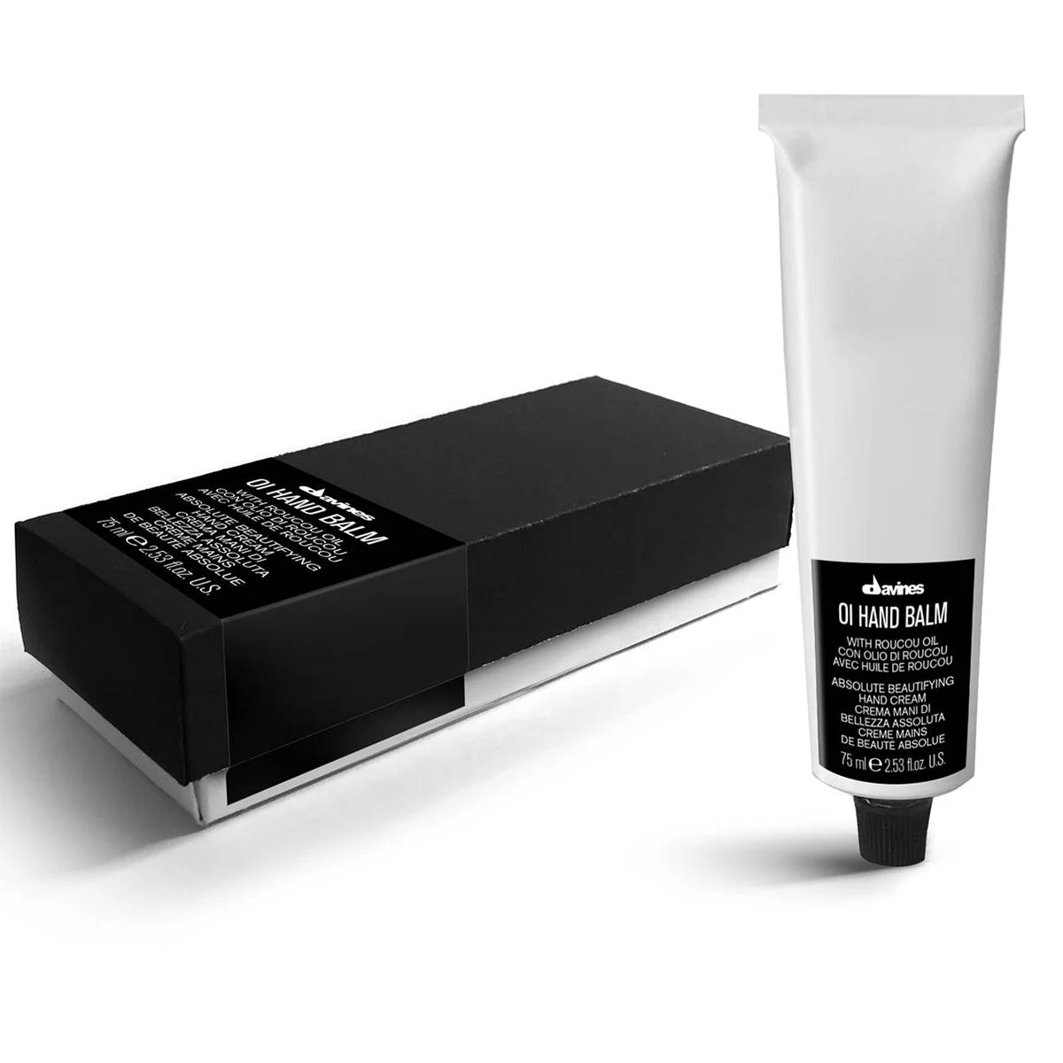 Tube med OI/Hand Balm handkräm bredvid en svart förpackningsbox, produkt för vård och återfuktning av händer med en minimalistisk design.
