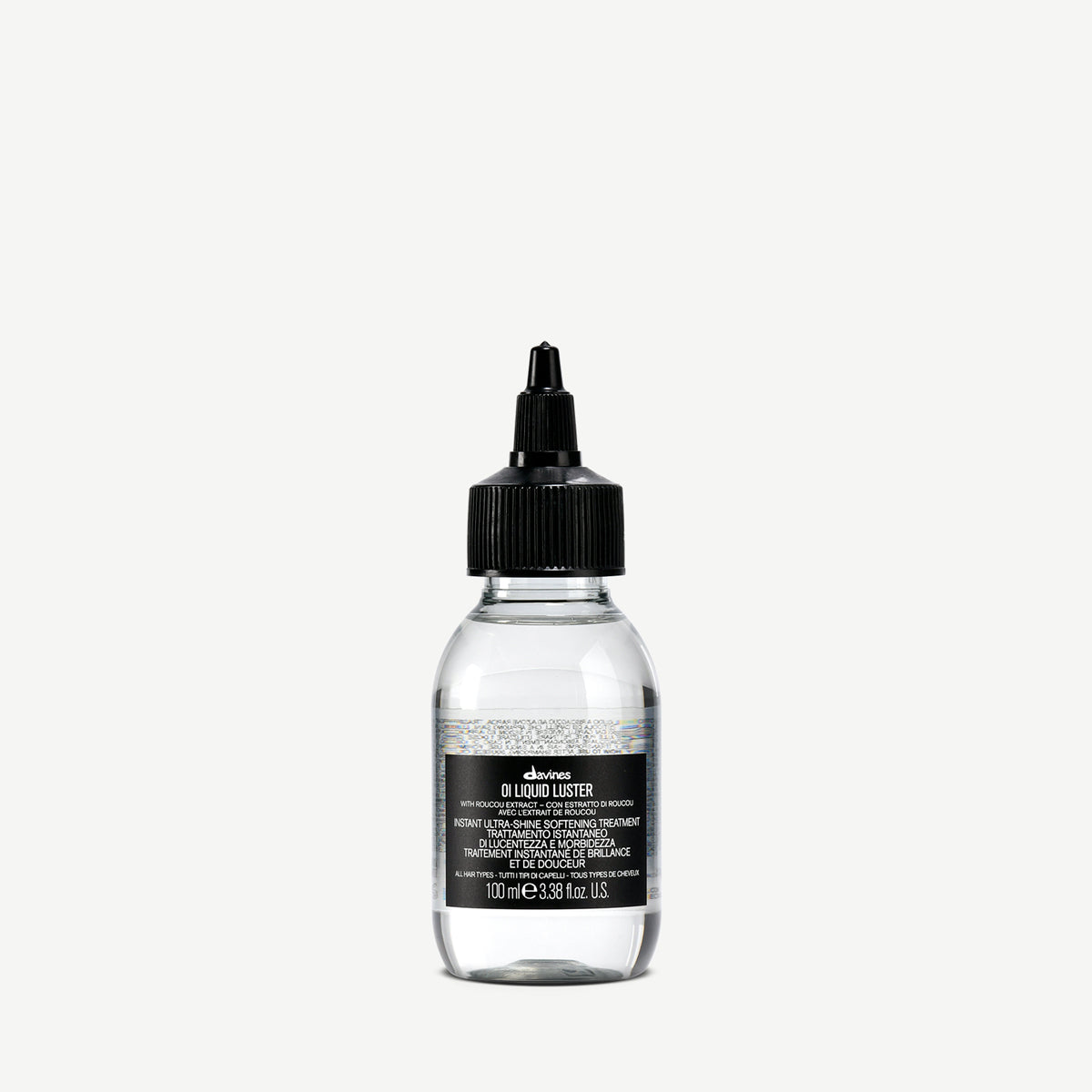 Transparent flaska med svart kork innehållande OI/Liquid Luster, en stylingprodukt för glansigt och återfuktat hår.