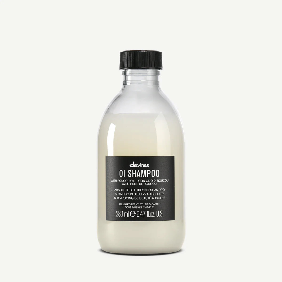 Flaska med OI/Shampoo från Davines, en mjölkvit schampo för alla hårtyper med svart etikett och svart lock.