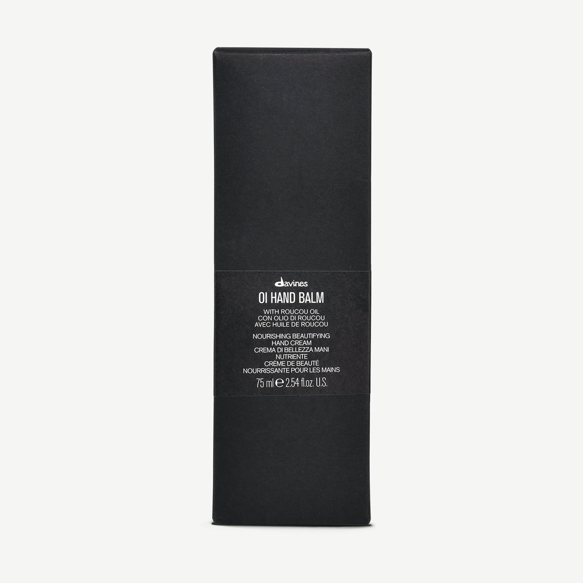 Svart förpackning för OI/Hand Balm med minimalistisk design och text som beskriver produkten som närande handkräm med Roucou-olja.