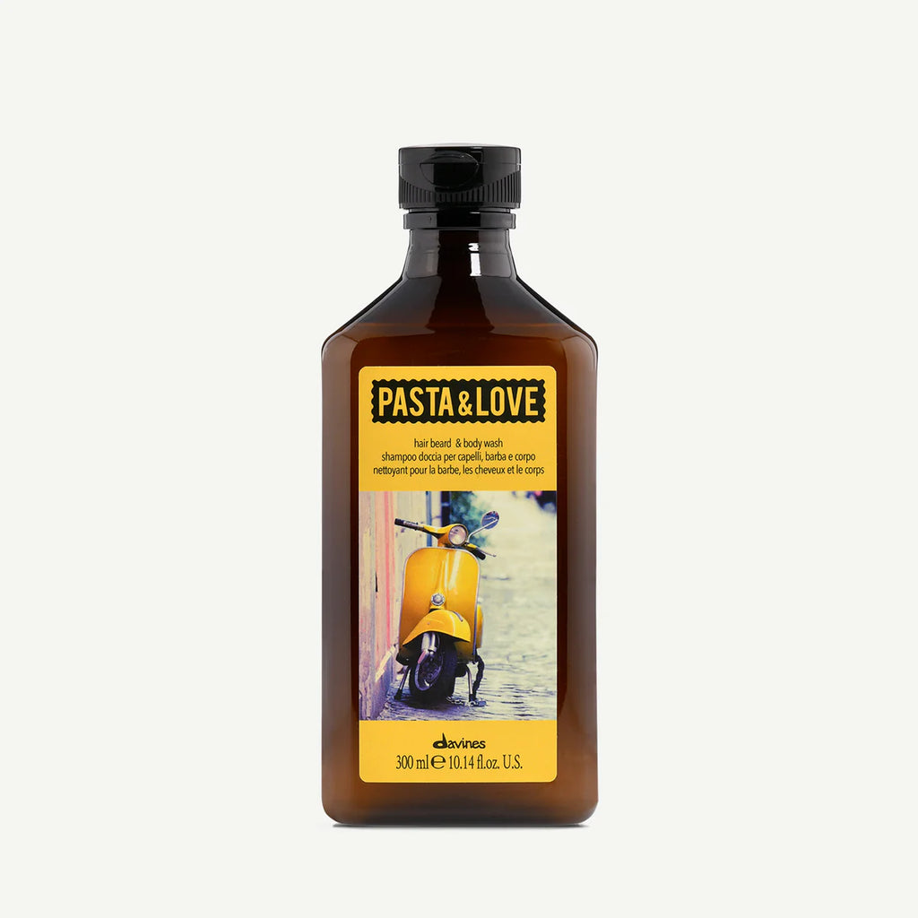 Flaska med Pasta & Love Hair Beard & Body Wash, ett miljövänligt schampo för hår, skägg och kropp i en brun förpackning med gul etikett och bild på en gul vespa.