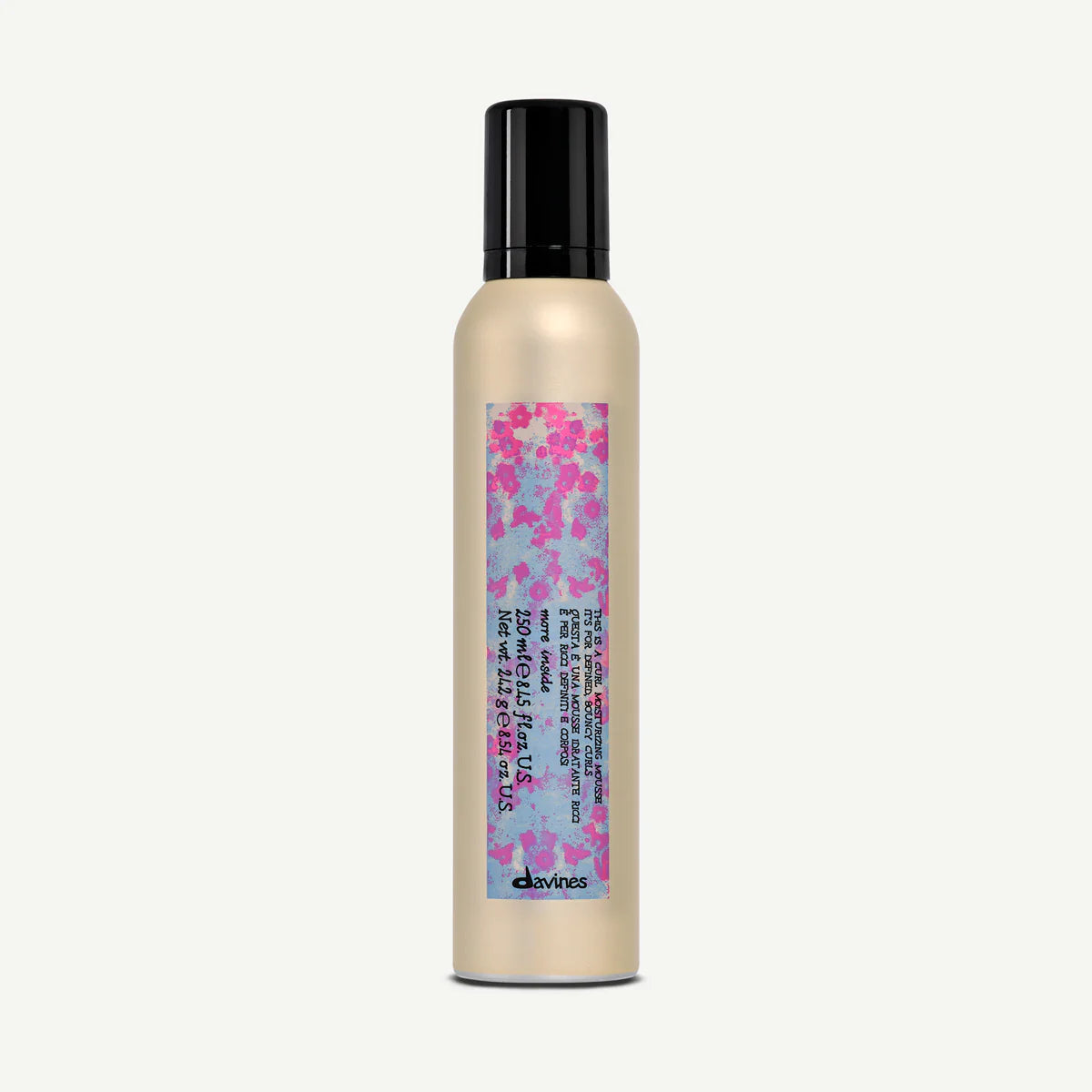 This is a Curl Moisturizing Mousse i en beige flaska med svart lock och färgglad etikett, en stylingprodukt för lockigt hår med återfuktande egenskaper.