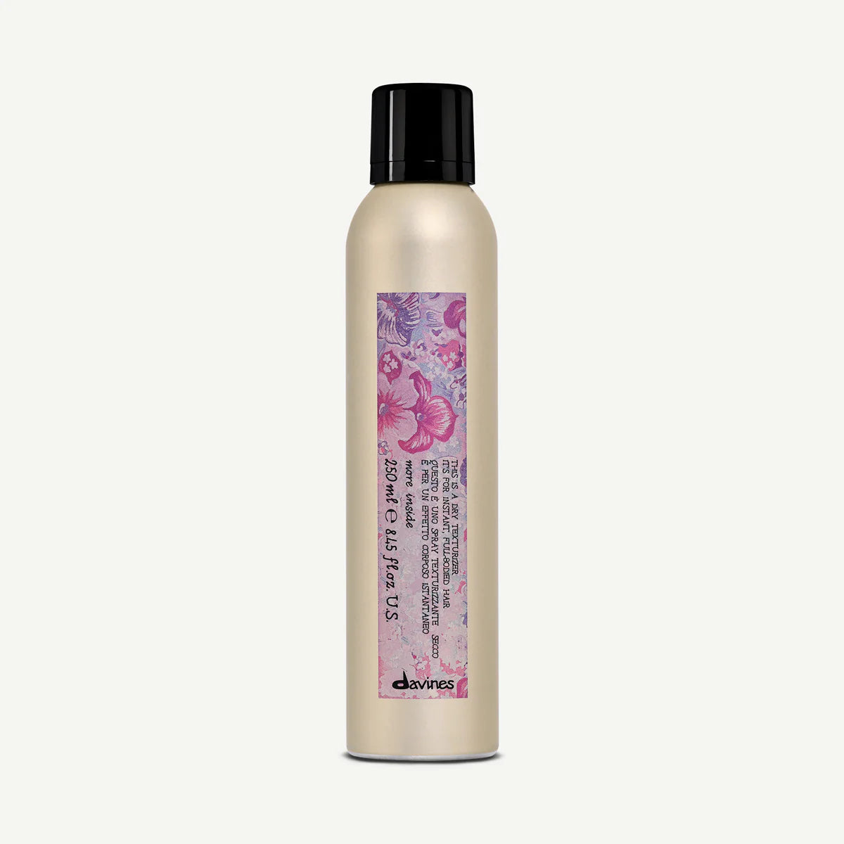 This is a Dry Texturizer i en elegant, beige sprayflaska med svart lock och färgglatt mönster som passar för styling och texturering av hår.