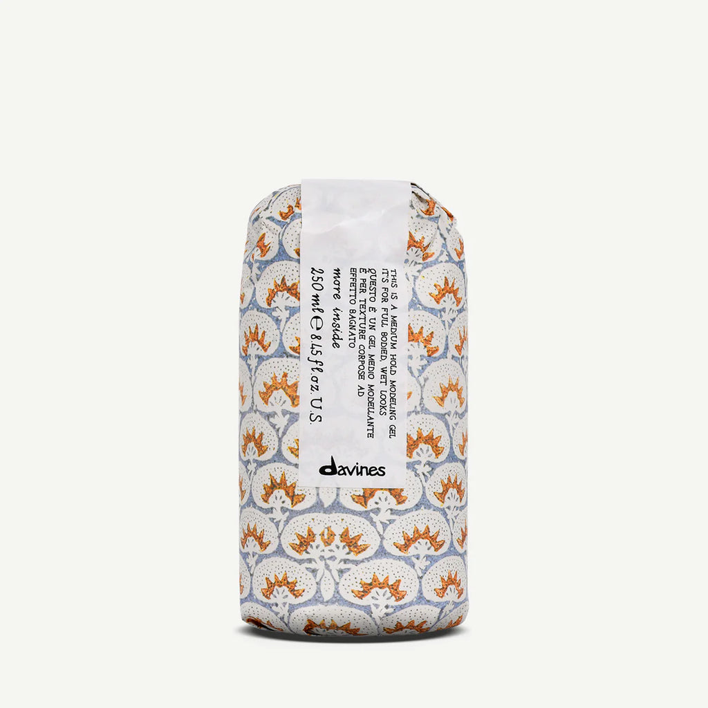 This is a Medium Hold Modeling Gel i en dekorativ förpackning med mönster i vitt, orange och grått, perfekt för hållbar styling och miljövänlig hårvård.