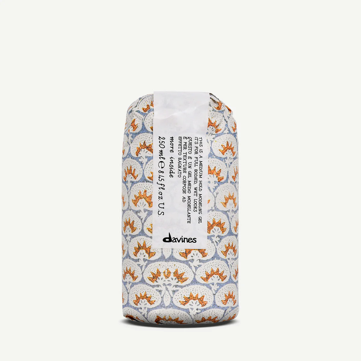 This is a Medium Hold Modeling Gel i en dekorativ förpackning med mönster i vitt, orange och grått, perfekt för hållbar styling och miljövänlig hårvård.