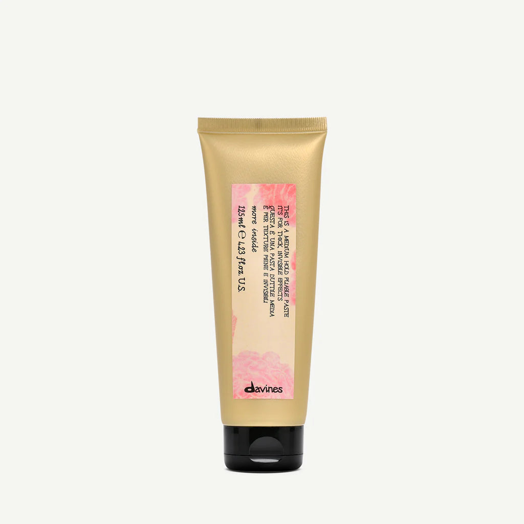 Tub med This is a Medium Hold Pliable Paste från Davines, en stylingprodukt för flexibelt och medelhårt hårfäste, i en miljövänlig förpackning.