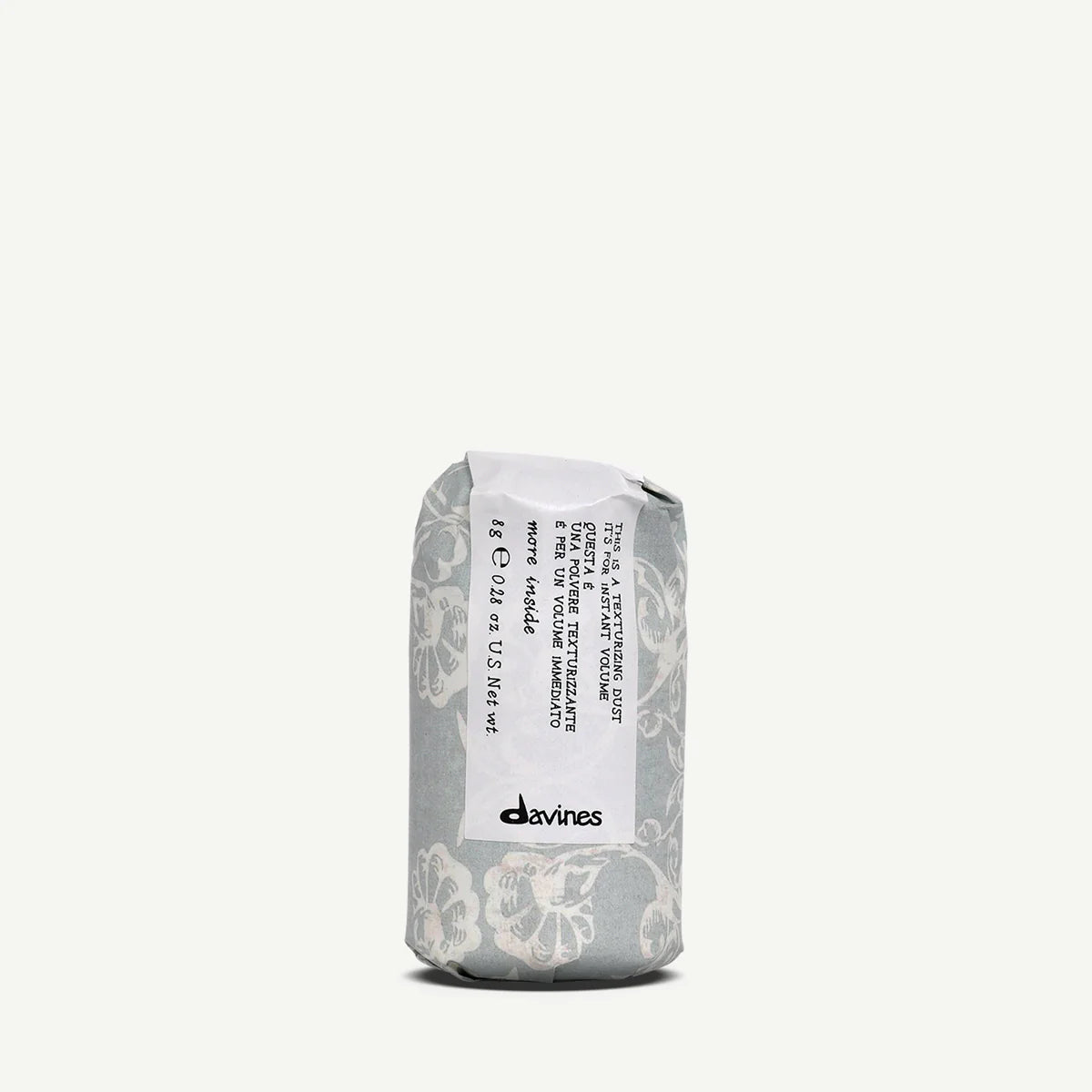 This is a Texturizing Dust i en dekorativ grå förpackning med blommönster, en stylingprodukt från Davines för textur och volym i håret.
