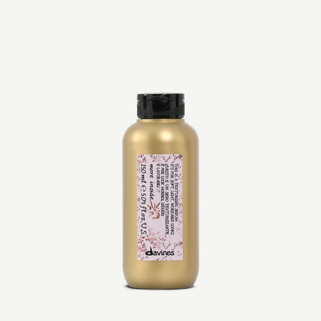 This is a Texturizing Serum i en matt guldflaska med svart kork, en stylingprodukt för textur och volym i håret.