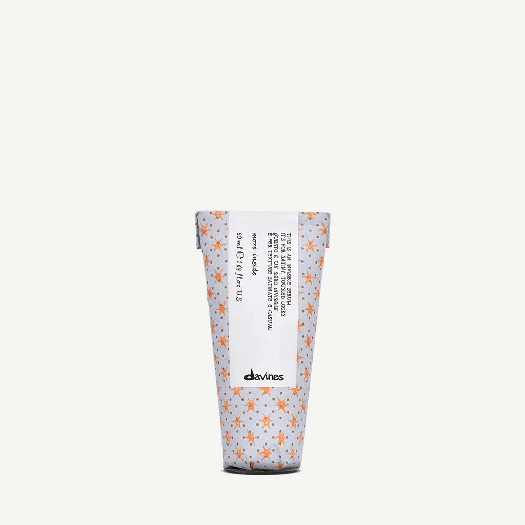 This is an Invisible Serum från Davines i en 50 ml förpackning, omgiven av en dekorativ design med små orange stjärnmönster på ljus bakgrund.