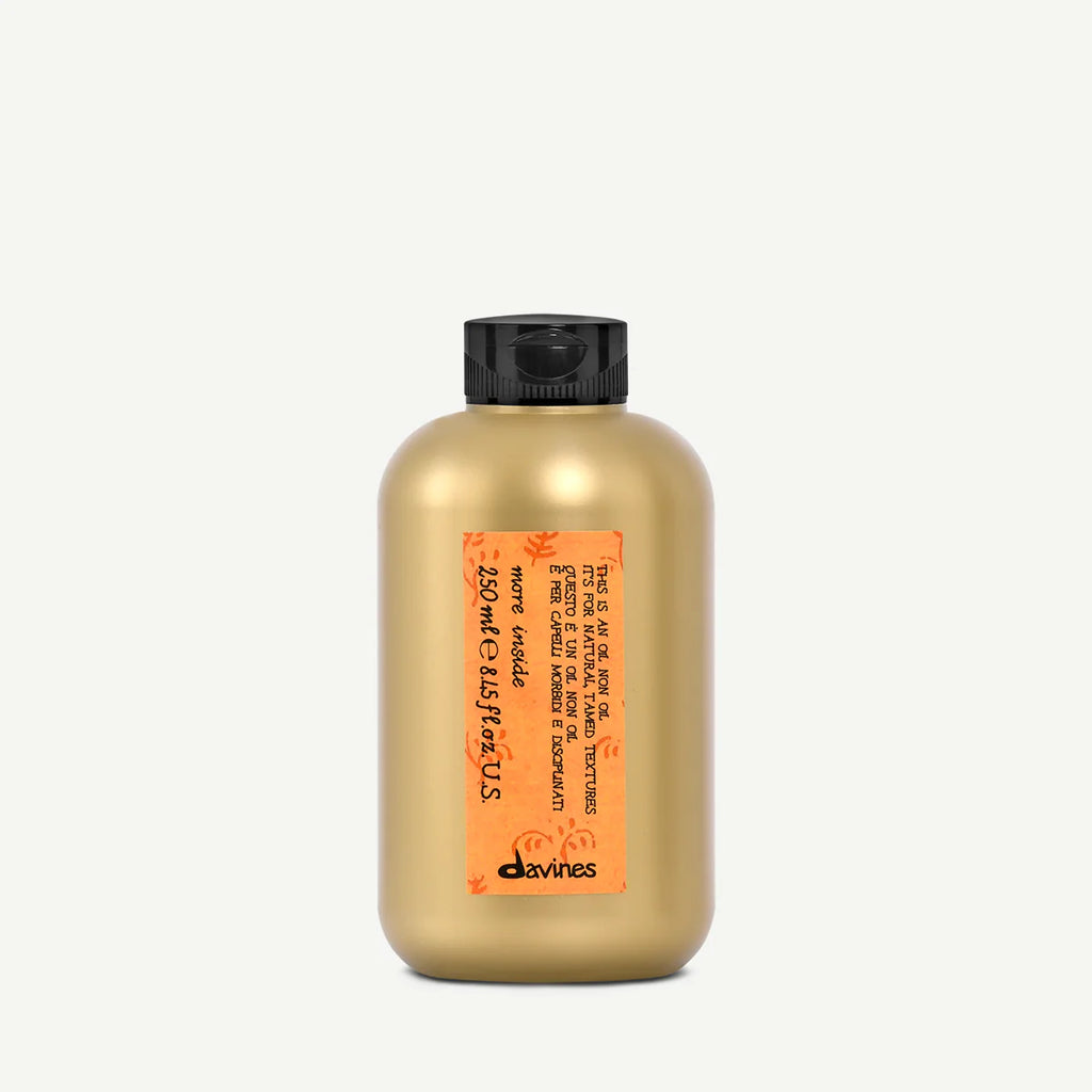 Flaska med miljövänlig hårvårdsprodukt This is an Oil non Oil från Davines med gyllene förpackning och orange etikett.