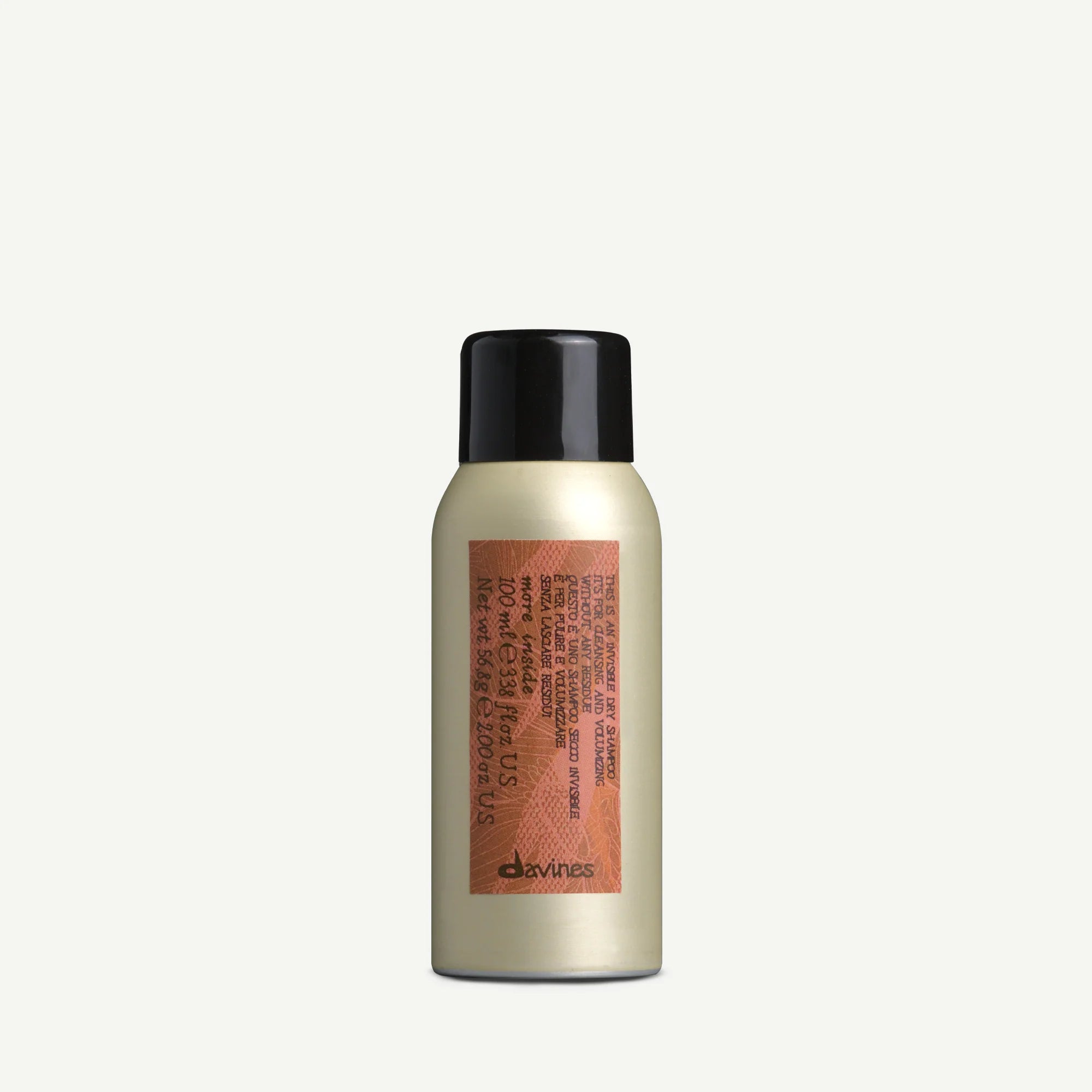 Produktflaska med svart lock och etikett i kopparfärg med text, innehållandes This is an invisible Dry Shampoo från Davines, ett miljövänligt stylingalternativ för fräscht hår utan vatten.