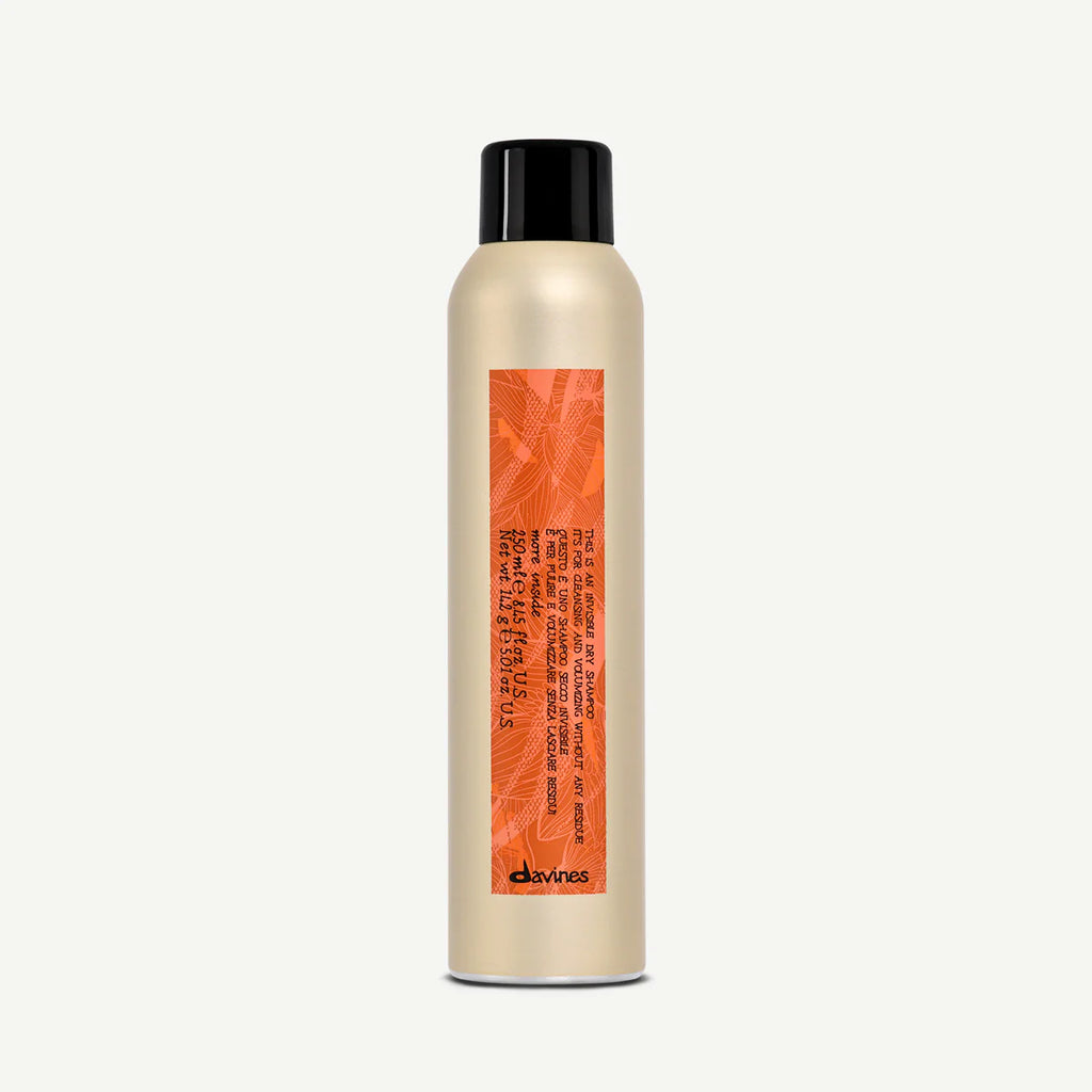 This is an invisible Dry Shampoo i en elegant beige sprayflaska med svart lock och orange etikett, perfekt för miljövänlig styling och fräscht hår utan tvätt.