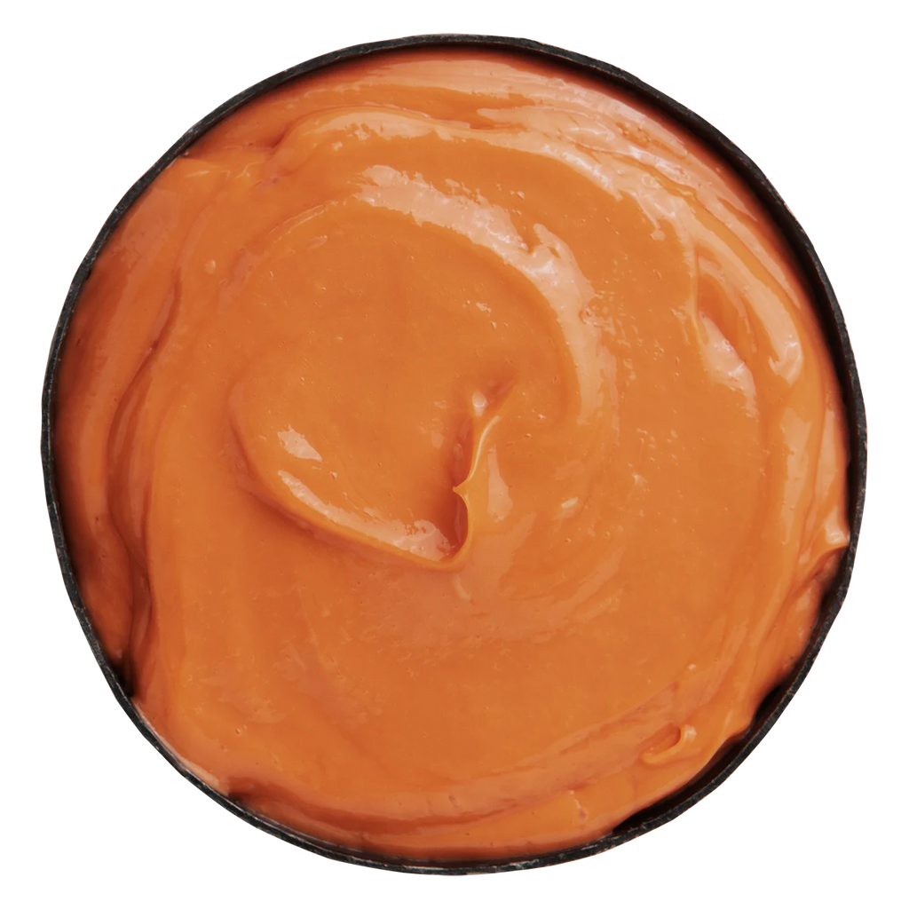 Krämig orange färgad balsamprodukt med jämn textur, Alchemic Creative Conditioner Coral, passar för vård och färgbehandling av hår.