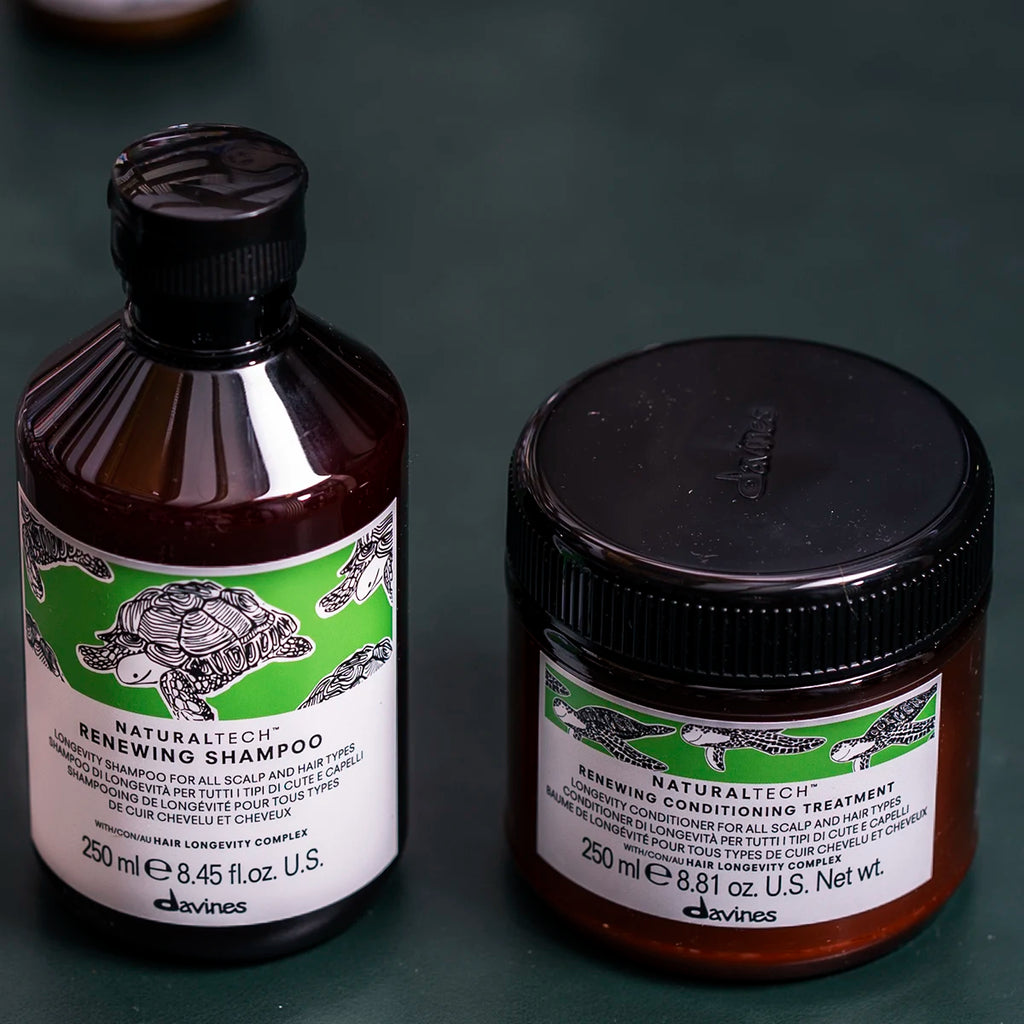 Bild på Naturaltech Renewing Conditioning Treatment tillsammans med schampo i bruna förpackningar med gröna etiketter, en hårinpackning för vård av hår och hårbotten.
